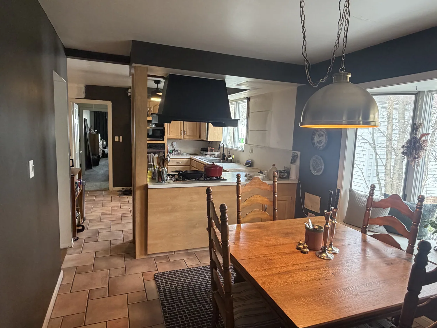 Kitchen before wall removal with a narrow opening and support dividing it from the dining area