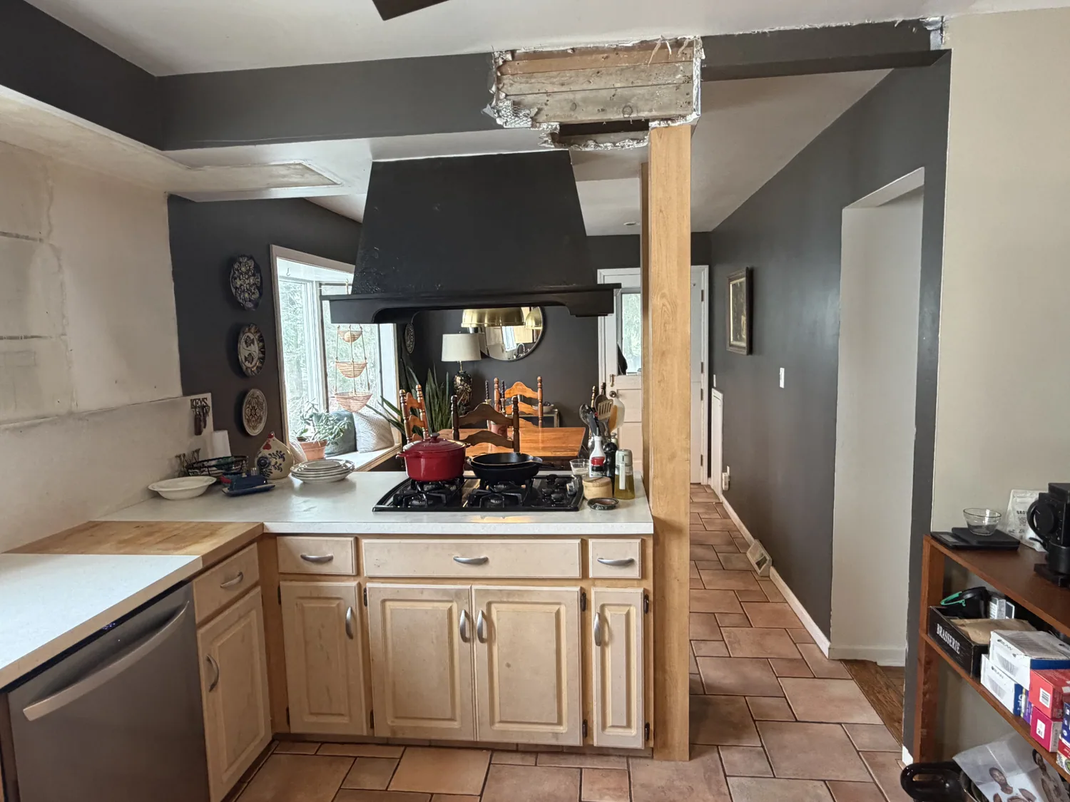 Kitchen during renovation with the wall opened to expose the structural framing for repair